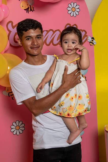 Papá cargando a bebé junto al pastel — Producciones Guzmán SV