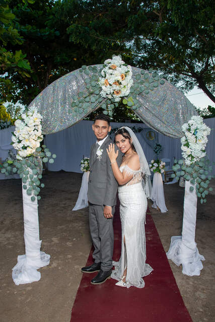 Novios bajo arco decorado — Producciones Guzmán SV