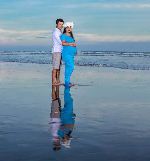 Pareja sonriente sosteniendo zapatitos de bebé — Producciones Guzmán SV