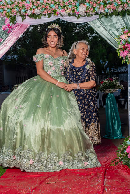 Sentada frente al póster con su corona — Producciones Guzmán SV