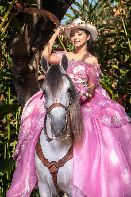 A caballo, ajustando el sombrero floreado — Producciones Guzmán SV
